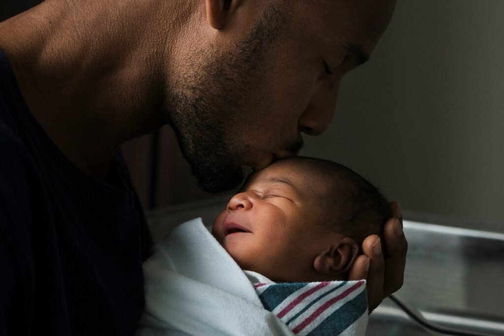 African father kissing baby in baby massage